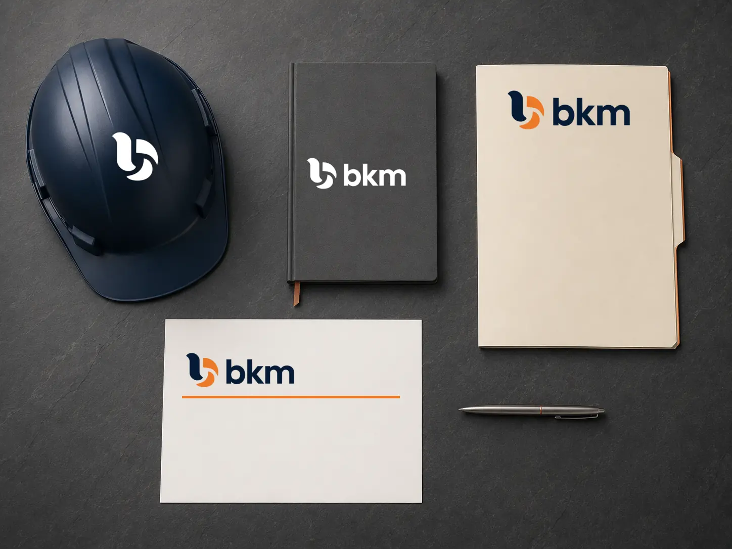 BKM identity applied to a helmet, notebook, folder, and letterhead
